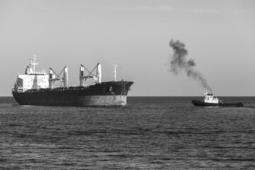 Fototapeta premium Bulk carrier and tug boat sail the Black Sea. Varna harbor