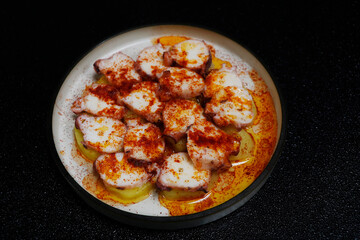 polpo alla gallega, is a popular spanish tapas dish with slow cooked octopus and boiled potato, paprika and olive oil