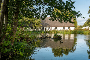 Fototapeta na wymiar white building at Esrum Abbey reflecting in the pond