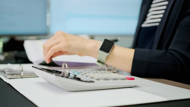 Close up shot of woman accountant working using calculator. Make payments on-line through bank system, analyze company charges calculate expenses concept