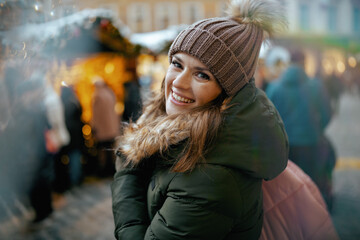 smiling modern female at christmas fair in city
