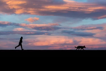 Papier Peint photo Lavable Couleur saumon Man and dog running on levee in California 