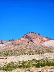 Fototapeta na wymiar Brightly-colored layered sediment mountains in Beatty, Nevada
