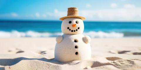 Fototapeten A cute upbeat  sand snowman on the beach in bright sunlight, with the sea or ocean in the background. Merry Christmas time, greeting Card. Winter Getaway by the Sea. Beach Christmas Vacation. © GT77