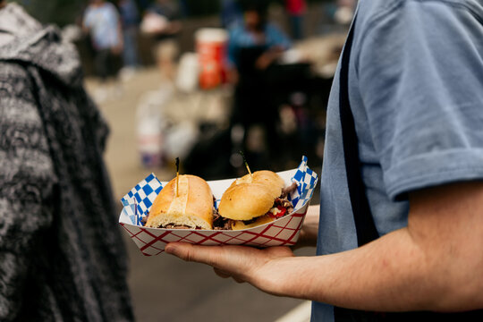 A person hold a classic american sandwich in the street of New York City, United States.