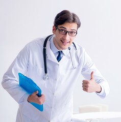 Man male pediatrician near baby bed preparing to examine