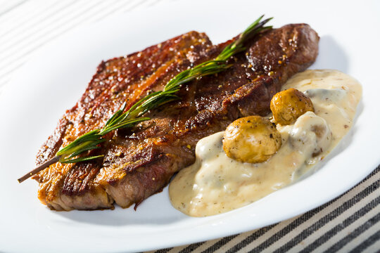 Photography of plate with beef entrecote with mushroom sauce in restaurante.
