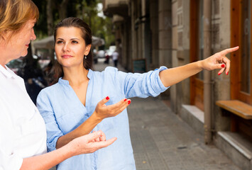 Friendly young woman with elderly mother exploring city sights during conjoint vacation..