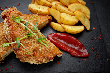 Pork schnitzel with potatoes, sauce and herbs