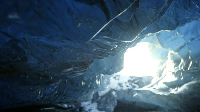 Dolly push in closeup of ice cave with water melting
