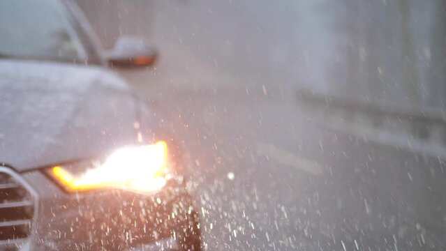 Car under the snow with headlights on. snowy weather. Stopping the car in the snow.burning headlight and the movement of the windshield wipers on a car under the falling snow.