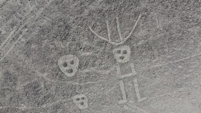  Three faces and multiple lines camera rising up of the Nazca Lines geoglyphs made in the soil of the Nazca Desert Aerial video