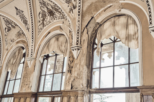  Abandoned soviet spa resort (sanatorium) Shakhter (Miner), in Tskaltubo, Georgia. Luxurious ancient hall with painted ceiling and arched windows. Stalin Empire style - Powered by Adobe