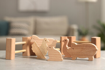 Fototapeta na wymiar Wooden animals and fence on light grey table indoors, closeup. Children's toys