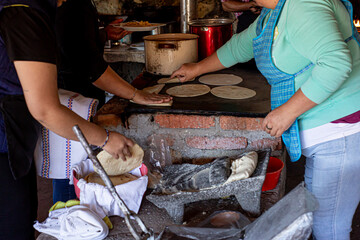mujer haciendo ricas tortillas de maiz en cocina rustica mexicana con la leña 