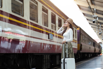 Woman traveler tourist walking with luggage at train station. Active and travel lifestyle concept