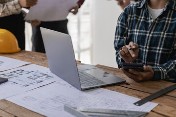 Architect interior designer working with home improvement documents for house design Persson Engineer - Hand drawn plans on print with architect equipment. Architects chatting at the table