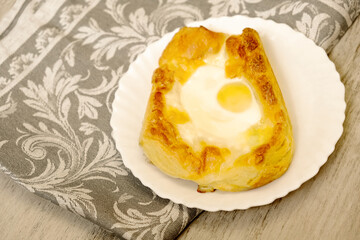 Dough boats filled with sulguni cheese and egg. Adjarian khachapuri. Traditional Georgian cuisine.