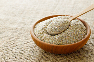 rye bran in bowl and in spoon on table with sackcloth