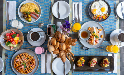 Desayuno saludable en acompañado de huevos, ensalada de frutas, panques tortillas, wafles salchichas. café jugos en un hotel.