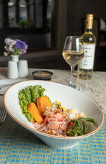 Ceviche de trucha acompañado de vino blanco.