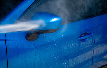 Car washing with high pressure water spray. Car cleaning. Auto care service concept. Vehicle...