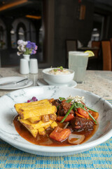 Lomo saltado acompañado de papas fritas arroz y limonada. en un restaurante de comida del Perú.