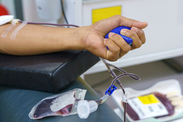 man as blood donor at donation with a bouncy ball holding in hand