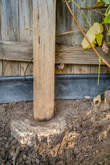 wooden backyard fence post with a rotten bottom prepared for a repair