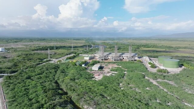 Aerial approaching shot of industrial factory in rural Area of Azua Dominican Republic - Central Monte Rio Power substation 