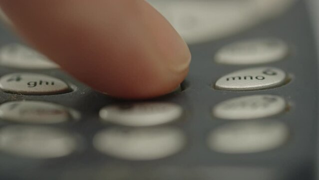 Finger pressing 555 on old cell phone