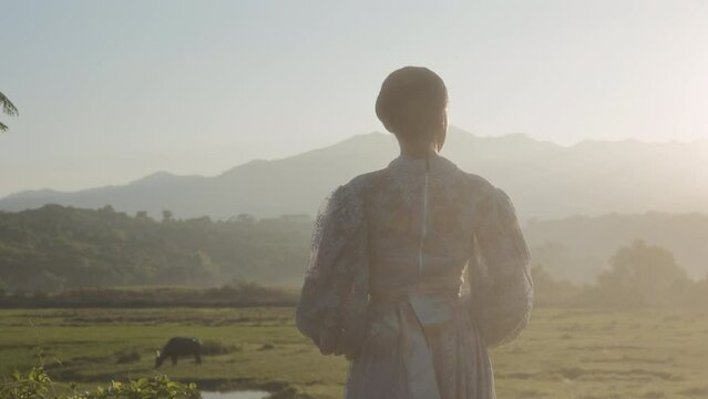 Woman Amidst Grassy Field And Distant Mountains
