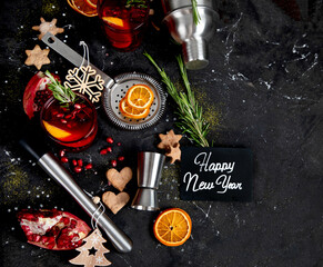 Winter christmas cocktail with pomegranate and rosemary in a glasses on black background. Top view