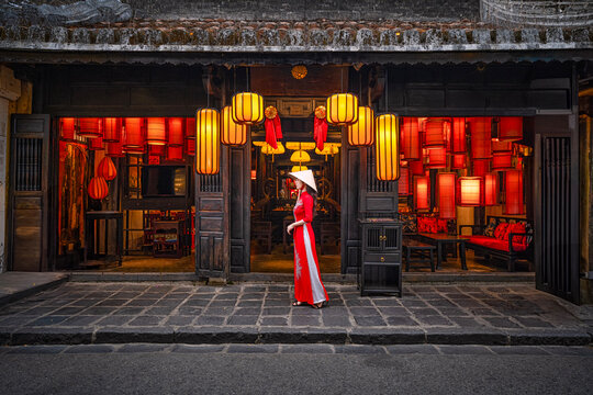 Tourists in traditional Vietnamese clothing look at lanterns in Hoi An ancient town. Traditional Vietnamese culture and lanterns at Hoi An ancient city Vietnam