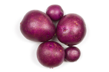 Tubers of purple potatoes on a white background. Purple potatoes close-up.