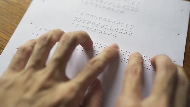 Blind person reading book. The Braille letters in a paragraph are A to Z and 1 to 0 in alphabetical order.