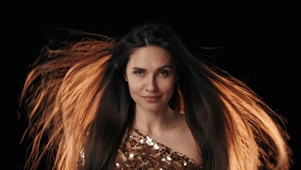 A middle-aged woman. Looking at the camera with a slightly haughty and smiling face, the light is...