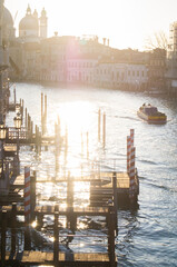 Beautiful, mesmerizing, evening in Venice, Italy. Canal, pear, winter, water, boat on water, reflection of sun in water - obrazy, fototapety, plakaty
