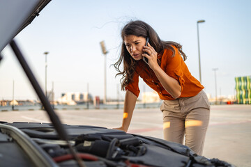 Woman with smartphone calling auto service because of car problem. Accident and breakdowns with auto concept. woman calling a car assistance service with her smartphone, her car has broken down