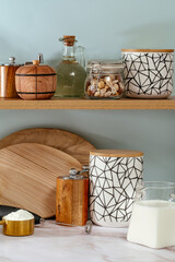 Wooden shelf with rustic cutting board, tea jar and decor in mod