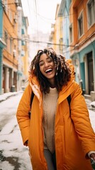Obraz premium Fictional happy young woman wearing a light orange snowman playing on a snowy city street.