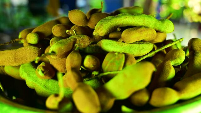 Tamarind pods in aluminum bowl, Thailand.