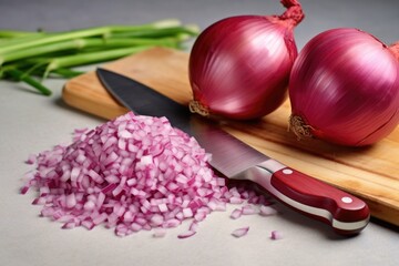 knife and a pile of freshly chopped onions on a marble board