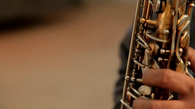 Close up handheld shot of musician playing wind instrument during event