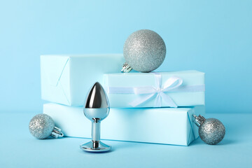 Metal butt plug with gifts on a blue background.