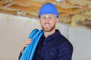 a happy builder holding pipes