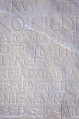 Historical inscription. Fragment of ancient law (imperial edict at Ancient Greek language), carved on marble block. Retro grunge background, film stylization, vertical. Kayseri, Turkey (Turkiye)