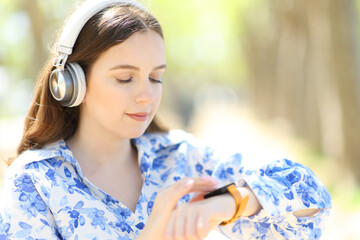 Woman wearing headphone using smartwatch