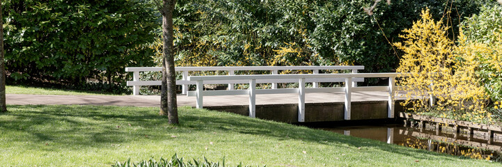 Panoramic image. Empty white wooden bridge in the park