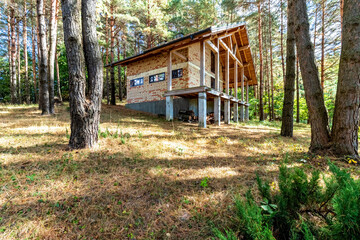 Fototapeta na wymiar A house under construction in a pine forest on a sunny autumn day